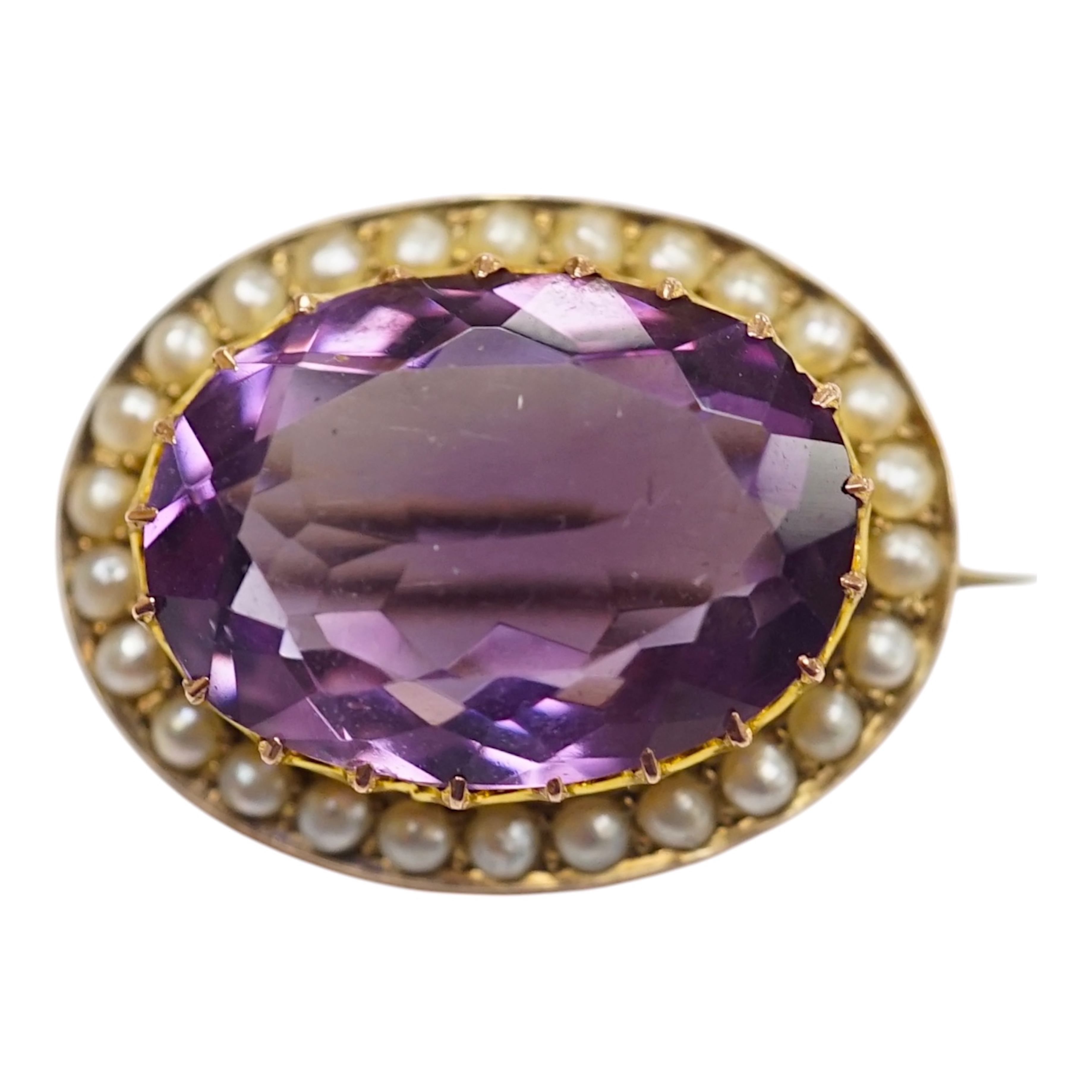 A mid 20th century 9ct and single stone oval cut amethyst set pendant brooch, with seed pearl border, 24mm, gross weight 4.8 grams. Condition - fair to good